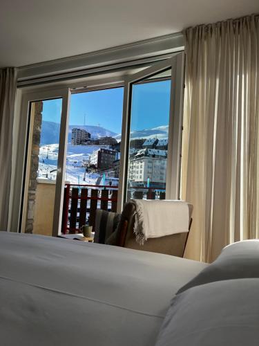 a bedroom with a bed and a window with a view at Menta - Nuevo! Encantador estudio vista a pistas in Pas de la Casa