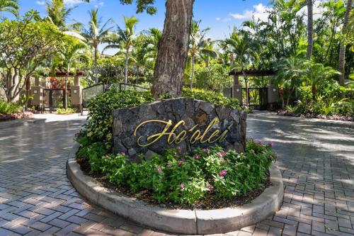 um sinal para um hotel com flores em frente a uma árvore em Ho'olei Garden View by Coldwell Banker Island Vacation em Wailea