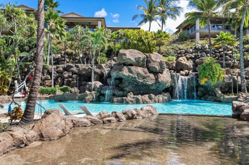 a pool with a waterfall in a resort at Ho'olei Garden View by Coldwell Banker Island Vacation in Wailea