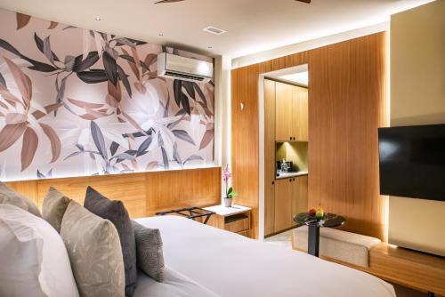 um quarto de hotel com uma cama e uma televisão de ecrã plano em Hotel Casona del Porvenir em Cartagena de Indias