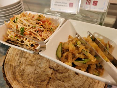 two dishes of food with tongs on a table at Hotel Osaka Castle in Osaka