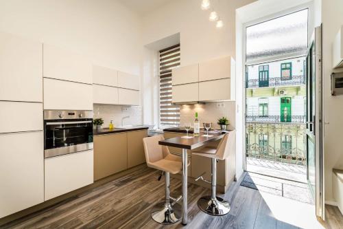una cocina con armarios blancos y una mesa con sillas. en Elizabeth Apartment in the heart of Budapest, en Budapest