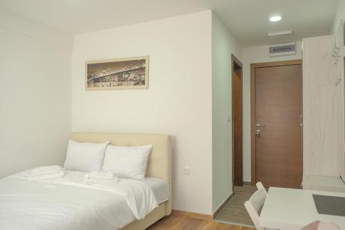 a bedroom with a white bed and a wooden floor at President Kop Alex in Kopaonik