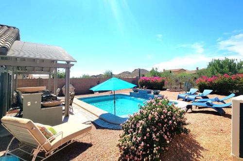 a backyard with a pool with chairs and a gazebo at Honeysuckle Oasis in Gold Canyon