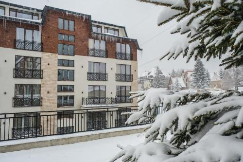 a snow covered apartment building in a city at President Kop Alex in Kopaonik