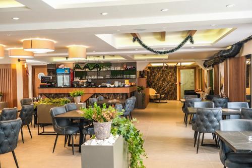 a restaurant with tables and chairs and a bar at President Kop Alex in Kopaonik