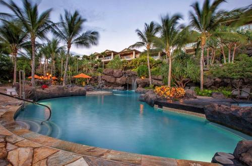 a swimming pool in a resort with palm trees at Ho'olei Ocean View by Coldwell Banker Island Vacations in Wailea