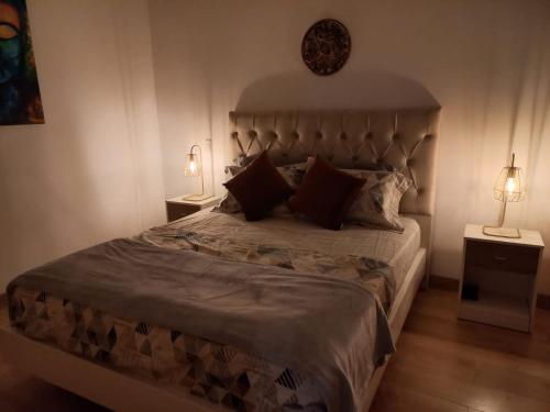 een slaapkamer met een groot bed met 2 lampen bij 1127 Apt in Sabaneta