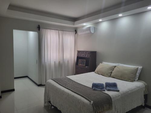 ein Schlafzimmer mit einem Bett mit zwei blauen Taschen darauf in der Unterkunft La Foret 2 dormitorios in Santa Cruz de la Sierra