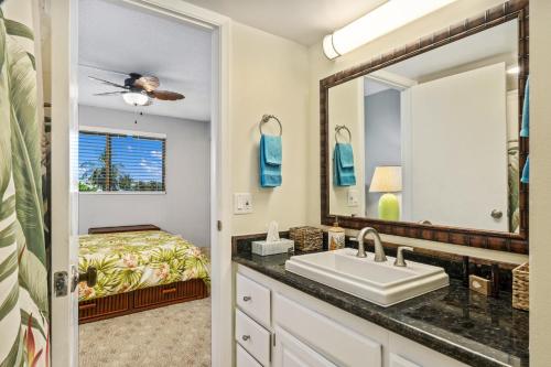 La salle de bains est pourvue d'un lavabo et d'un miroir. dans l'établissement Big Island White Sands Village by Coldwell Banker Island Vacations, à Kailua-Kona