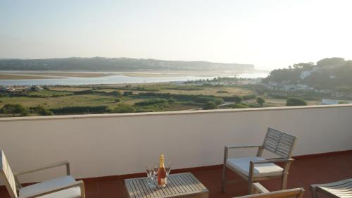 a room with two chairs and a table with a view at Casa Feliz Obidos Lagoon and sea view in Foz do Arelho