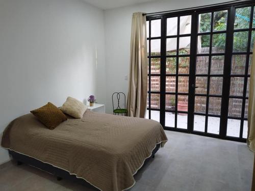 a bedroom with a bed and a large window at Casa Mango amplia con alberca y cerca de la Media Luna !!! in Río Verde