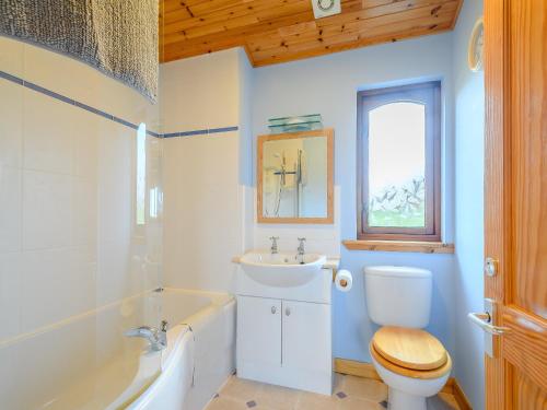 a bathroom with a tub and a toilet and a sink at Ard Cuan in Torbeg