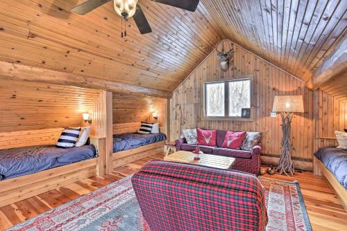 een woonkamer met houten wanden en houten vloeren bij Lakefront Cabin Retreat, 2-Acre Lot with Deck! 