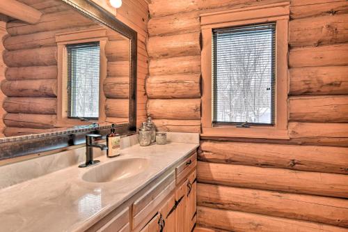 een badkamer met een wastafel en een spiegel bij Lakefront Cabin Retreat, 2-Acre Lot with Deck! 
