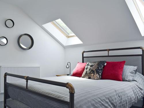 リドニーにあるPerivale Lodgeのベッドルーム1室(赤い枕と鏡付きのベッド1台付)