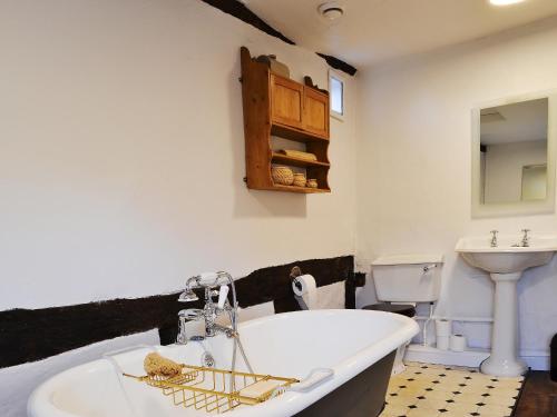 a bathroom with a white tub and a sink at Coppice Hill House in Bishops Waltham