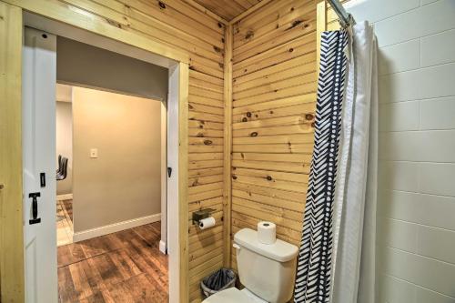 baño con aseo y pared de madera en Mullens Cabin with Gas Grill and Mountain Views!, en Mullens