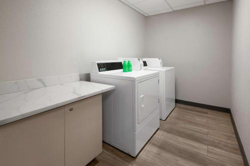 a small white room with a washer and a counter at La Quinta Inn by Wyndham Columbus Dublin in Dublin