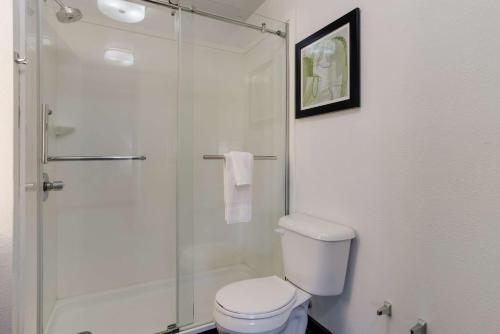 a bathroom with a toilet and a glass shower at Best Western Grants Inn in Grants