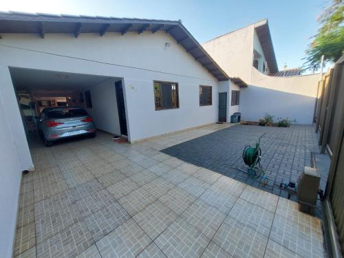 een auto geparkeerd in een garage naast een huis bij Quarto Deluxe em Foz piscina wifi estacionamento cozinha E AR in Foz do Iguaçu