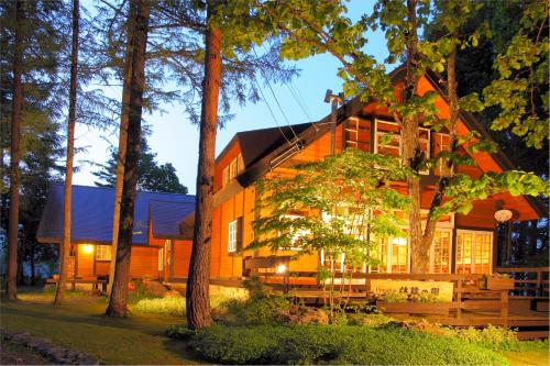 Una casa en el bosque por la noche en Pension Ringo-no Ki en Hakuba