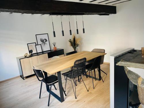 a dining room with a wooden table and chairs at L'antre du loup in Stavelot