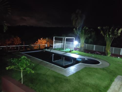 a backyard at night with a swimming pool at SITIO EM IBIUNA CONDOMINIO RECREIO VERDE in Ibiúna