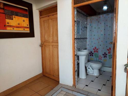 Baño con aseo junto a una puerta en Alojamiento de 2 Habitaciones con Baño Privado en Cuzco