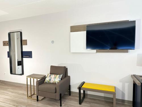 a living room with a chair and a flat screen tv at Comfort Inn & Suites in Barrie