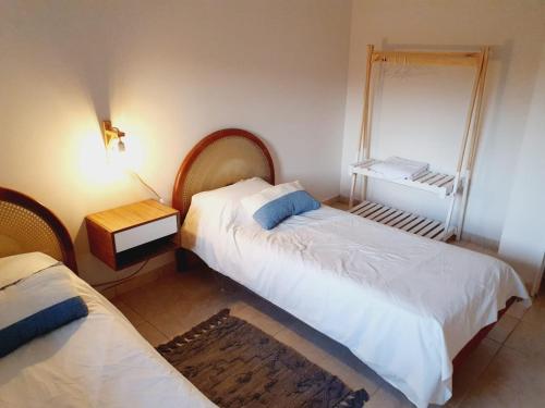 1 dormitorio con 2 camas y espejo en la pared en Casa Drummond-Luján de Cuyo en Luján de Cuyo