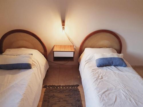2 camas en una habitación pequeña con una mesa en el suelo en Casa Drummond-Luján de Cuyo en Luján de Cuyo