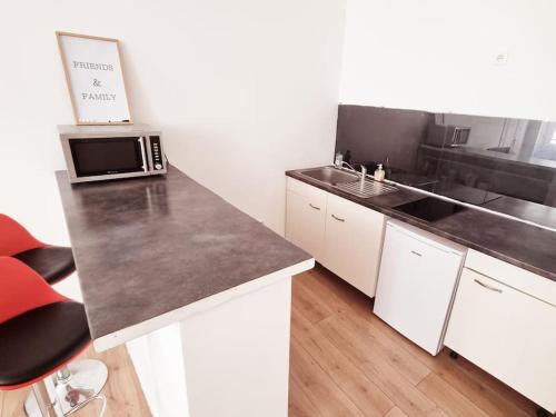 a kitchen with a counter top and a microwave at Le Cédralie Cours Julien, La plaine - Lumineux in Marseille