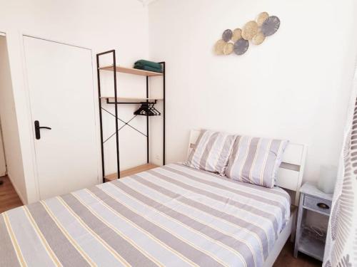 a bedroom with a striped bed and a white door at Le Cédralie Cours Julien, La plaine - Lumineux in Marseille