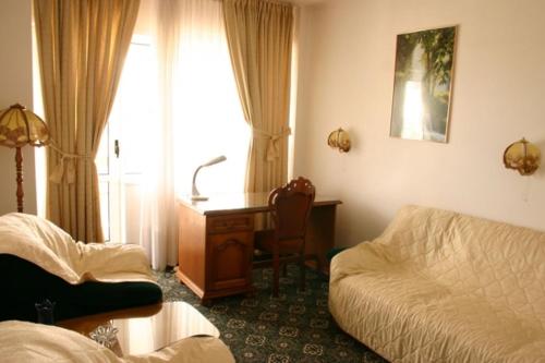 a hotel room with a desk and a bed and a bed and a desk at Hotel Decebal in Bacău