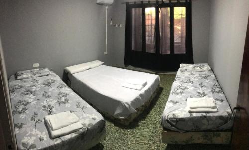 2 camas en una habitación con ventana en Deptos Doña Benigna en Puerto Iguazú