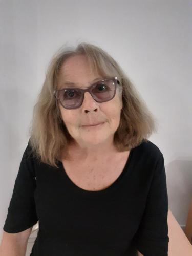 a woman wearing glasses is smiling at the camera at Chez Françoise in Noumea