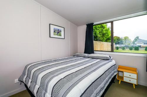 a bedroom with a bed and a window at Methven Ski Bach in Methven