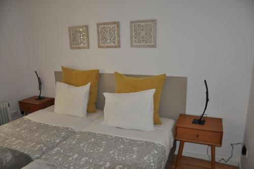 a bedroom with a bed with pillows and two tables at Koka's Apartment in Porto
