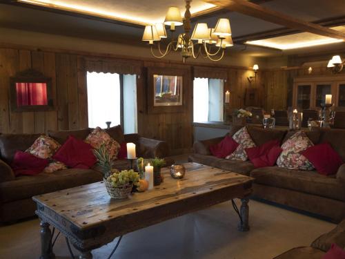 a living room with couches and a table with candles at Comfortable Holiday Home in Vielsalm near Lake in Vielsalm