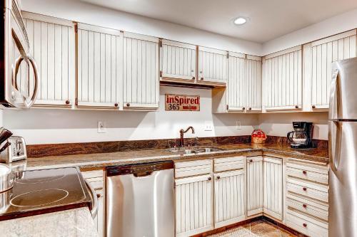 una cucina con mobili bianchi e un lavandino di PARK STATION 134 condo a Park City