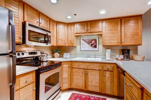 a kitchen with wooden cabinets and stainless steel appliances at PARK STATION 233 condo in Park City