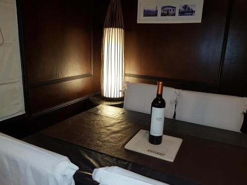 uma garrafa de vinho sentada numa mesa numa sala em Islavinia em Tigre