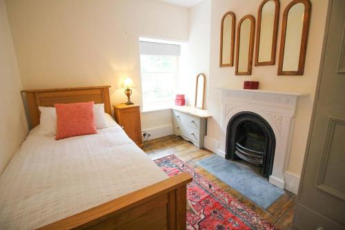 a bedroom with a bed and a fireplace at Bossy Castle in Boscastle