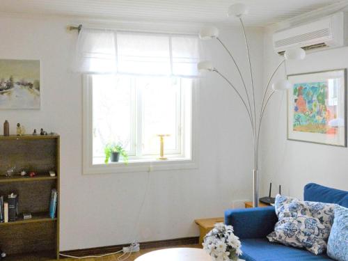 a living room with a blue couch and a window at 3 person holiday home in HAMMARÖ-By Traum in Hammarö