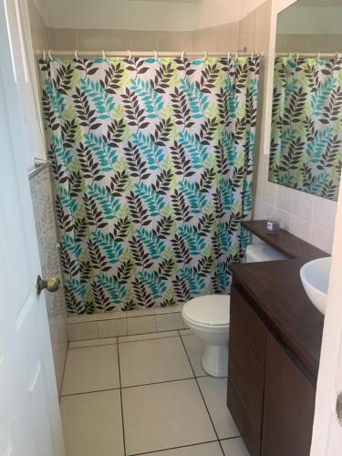 a bathroom with a shower curtain with a toilet at MonBlanc in San Salvador