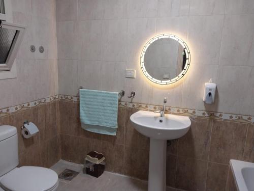 a bathroom with a sink and a mirror and a toilet at compound city towers elwaha in Cairo