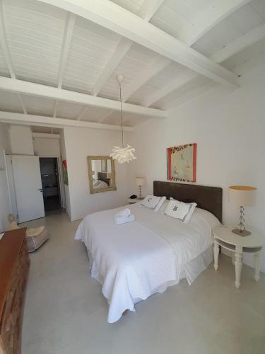 a bedroom with a large white bed and a table at Casa Bikini in Punta del Este