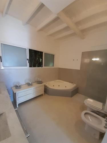 a bathroom with a tub and a toilet and a sink at Casa Bikini in Punta del Este
