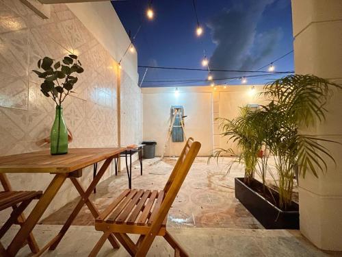una habitación con mesa, banco y plantas en Xikama Studios by Andiani Travel en Cancún